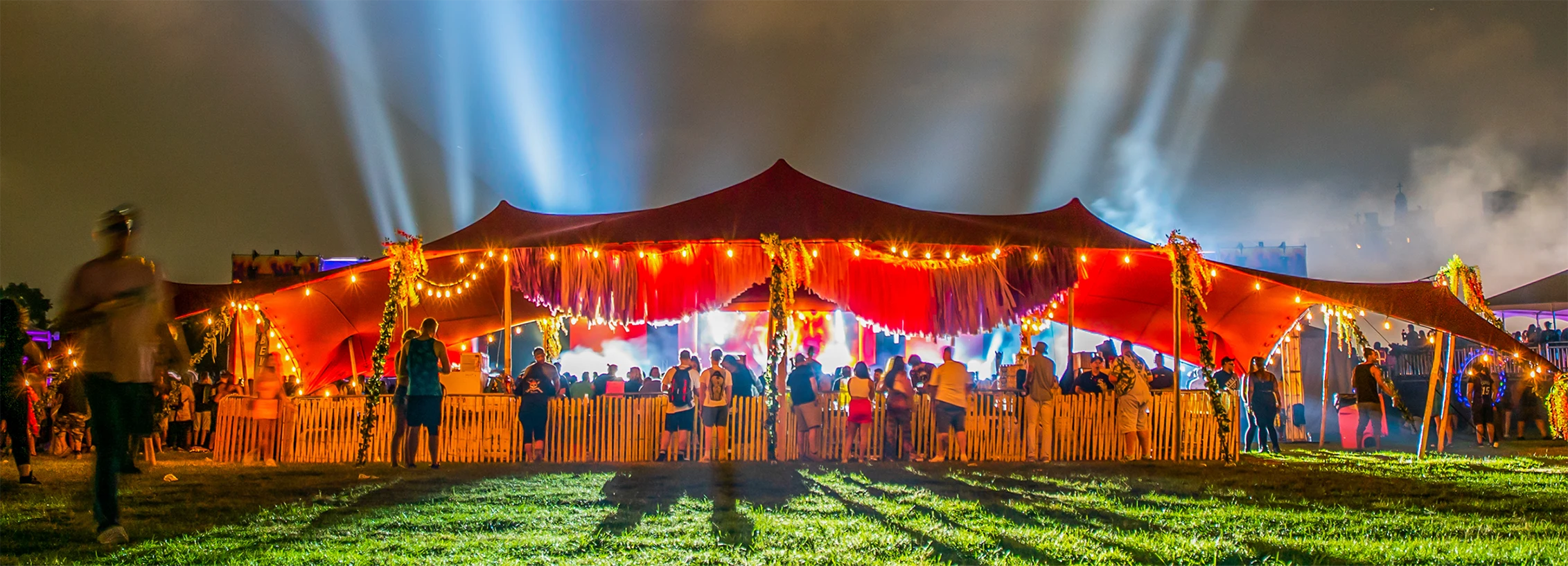 Families enjoying festival experience under stretch tent structure